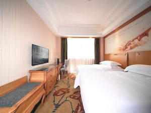 um quarto de hotel com duas camas e uma televisão de ecrã plano em Vienna Hotel Shenzhen Nanxin Road em Shenzhen