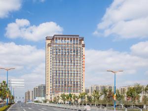 a tall building on the side of a road at Vienna Hotel Songjiang Wanda Guangfulin Road in Songjiang