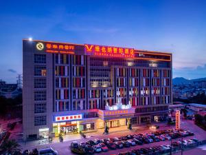 a large building with cars parked in a parking lot at Vienna Classic Hotel Guangzhou Yanling Road in Guangzhou