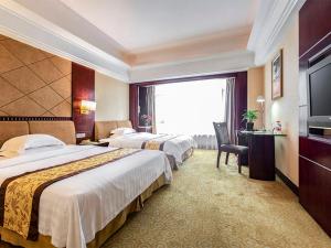 een hotelkamer met 2 bedden en een televisie bij Vienna International Hotel Dongguan Changping Swan Lake Road in Dongguan