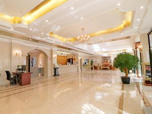 un gran vestíbulo con una planta en el medio en Vienna Hotel Shanghai Hongqiao National Convention Centre en Shanghái