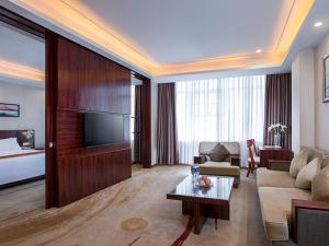 a living room with a couch and a television in a hotel room at Vienna Classic Hotel Guangzhou Yanling Road in Guangzhou