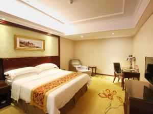 een hotelkamer met een groot bed en een bureau bij Vienna 3 Best Hotel Sheyang Jiefang Rd in Sheyang