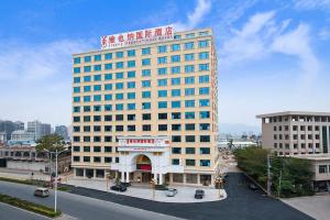 a large building with a sign on top of it at Vienna International Hotel Puning International Commodity City in Puning