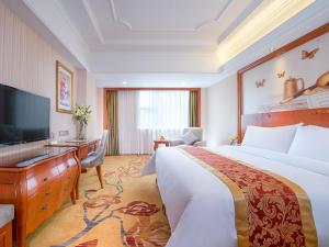 a hotel room with a bed and a desk and a television at Vienna Hotel Shenzhen Bantian South Huancheng Road in Shenzhen