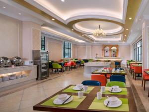 a restaurant with tables and chairs and a cafeteria at Vienna 3 Best Hotel Foshan Nanhai Film Studio City in Nanhai