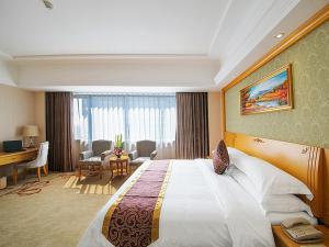 a hotel room with a large bed and a desk at Vienna Hotel Guilin Wanfu Square in Guilin