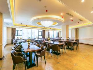 een grote eetkamer met tafels en stoelen bij Vienna Hotel Shanghai Hongqiao National Convention and Exhibition Center Wanda in Jiading
