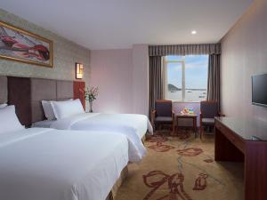 Un pat sau paturi într-o cameră la Vienna Hotel Guangdong Shanwei Feicui Bay