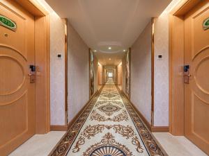 a hallway with a long hallway with a tile floor at Vienna Hotel Nanning Gaoxin District in Nanning