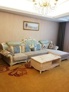 uma sala de estar com um sofá e uma mesa em Vienna Hotel Hefei East Changjiang Road em Hefei