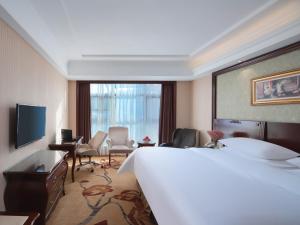 a hotel room with a large bed and a living room at Vienna Hotel Nanjing Baijiahu Ximenzi in Nanjing