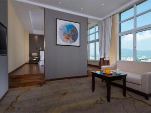 a living room with a couch and a table at Vienna International Hotel Diecai Wanda High Speed ​​Rail Station in Guilin
