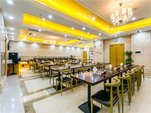 a restaurant with tables and chairs in a room at Vienna International Hotel Shanghai Pudong New International Exbition Central in Shanghai