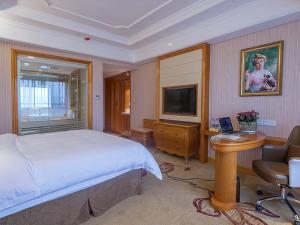sypialnia z łóżkiem, biurkiem i telewizorem w obiekcie Vienna International Hotel Nanjing Hehai University Station w mieście Zhucun