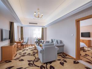 um quarto de hotel com um sofá e uma televisão e uma sala de estar em Vienna Hotel (Dangtu East Railway Station, Ma'anshan, Anhui) em Ma'anshan
