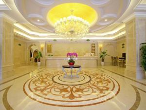 a large lobby with a table and a chandelier at Vienna Hotel Waigaoqiao in Shanghai