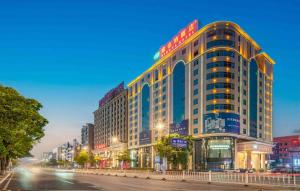 un gran edificio en una calle de la ciudad por la noche en Vienna Hotel Dongguan Houjie Exhibition Center, en Dongguan