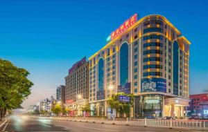 a large building on a city street at night at Vienna Hotel Dongguan Houjie Exhibition Center in Dongguan