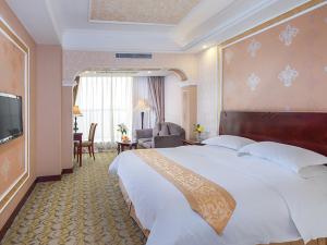 una camera d'albergo con un grande letto e una TV di Vienna Hotel Songgang Yanchuan Road a Bao'an