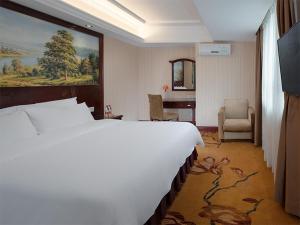 東莞的住宿－維也納酒店東莞長安振安中路店，酒店客房设有一张大床和一张书桌。
