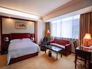 Cette grande chambre comprend un lit et un canapé. dans l'établissement Vienna Hotel Zhongkai Road Branch, à Huizhou
