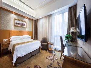Vienna Hotel Jiangsu Changzhou Qingfeng Park في تشانغتشو: غرفه فندقيه بسرير ونافذه