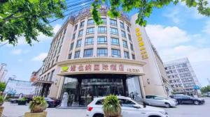 un edificio con coches estacionados frente a él en Vienna International Hotel Shanghai Hongkou Guangyue Road en Shanghái