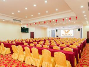 a large room with rows of chairs and a screen at Vienna Hotel Huizhou Huiyang Danshui Road in Huizhou
