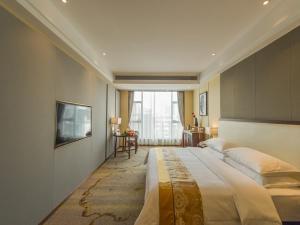 a large bedroom with a large bed and a television at Vienna International Hotel Diecai Wanda High Speed ​​Rail Station in Guilin +11 photos