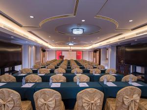 a conference room with rows of tables and chairs at Vienna International Hotel Huizhou Huidong Honghaiwan in Huidong