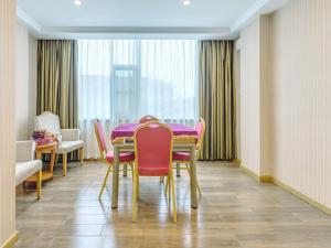 Vienna Hotel Guilin AIrport Road Rongshan في قويلين: غرفة طعام مع طاولة وكراسي وردية