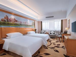 um quarto de hotel com duas camas e uma televisão em Vienna Hotel (Dangtu East Railway Station, Ma'anshan, Anhui) em Ma'anshan
