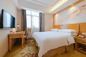 um quarto de hotel com uma cama grande e uma secretária em Vienna 3 Best Hotel Shenzhen South University of Science and Technology of China em Shenzhen