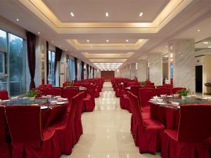 a dining room with red chairs and tables in a restaurant at Vienna Classic Hotel (Anlu Hengkun) in Zhulin