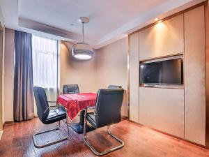 une salle à manger avec une table, des chaises et une télévision dans l'établissement Vienna International Hotel Huhan Jiedaokou, à Wuhan