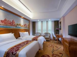 a hotel room with two beds and a flat screen tv at Vienna Hotel Jieyang Danpu Road in Jieyang