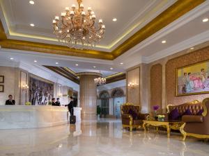 a lobby with a chandelier and a bar in a hotel at Vienna International Hotel Shenzhen Longgang Lilang in Longgang