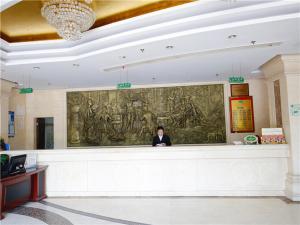 a woman standing behind a counter in a building at Vienna Hotel Suzhou Luokou Furniture Store in Suzhou