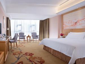 a hotel room with a bed and a table and chairs at Vienna Hotel Guangzhou Panyu Huanan Country Garden in Guangzhou