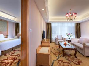 a hotel room with a bed and a living room at Vienna Hotel Guangdong Heyuan Lianping in Lianping