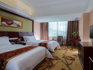 Vienna Hotel Nanning Xianhu في نانينغ: غرفه فندقيه سريرين وتلفزيون