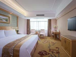 Habitación de hotel con cama y TV de pantalla plana. en Vienna Hotel Nanning Qingxiu Mountain, en Nanning