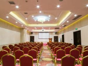 Sala de conferencias con sillas rojas y pantalla de proyección en Vienna Hotel Shanghai Happy Valley en Songjiang