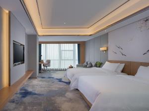 Cette chambre comprend 2 lits et une télévision à écran plat. dans l'établissement Venus Royal Hotel(Foshan Kuiqi Road Metro Station), à Foshan