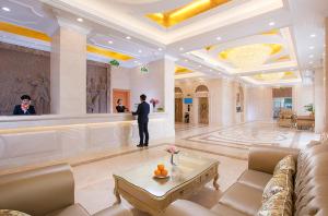 a man standing in a large room with a lobby at Vienna International Hotel Puning International Commodity City in Puning