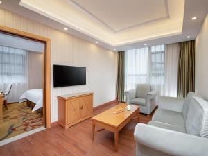 a living room with a couch and a tv in a room at Vienna Hotel Hunan Xincheng Guoji in Liuyang +5 photos