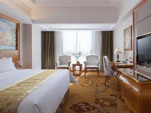 una camera d'albergo con un grande letto e una TV di Vienna International Hotel Changsha Shumuling Subway Station a Changsha