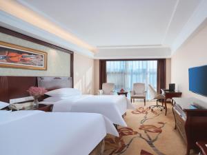 a hotel room with two beds and a television at Vienna Hotel Nanjing Baijiahu Ximenzi in Nanjing