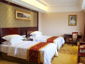 a hotel room with two beds and a desk at Vienna International Hotel Shanghai Pudong Xinchang Old Town Subway Station in Nanhui